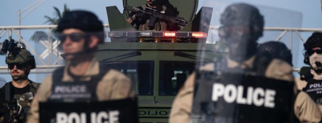 A Miami Police officer watches protestors from a armored vehicle during a rally in response to the recent death of George Floyd in Miami, Florida on May 31, 2020. - Thousands of National Guard troops patrolled major US cities after five consecutive nights of protests over racism and police brutality that boiled over into arson and looting, sending shock waves through the country. The death Monday of an unarmed black man, George Floyd, at the hands of police in Minneapolis ignited this latest wave of outrage in the US over law enforcement's repeated use of lethal force against African Americans -- this one like others before captured on cellphone video. (Photo by Ricardo ARDUENGO / AFP) (Photo by RICARDO ARDUENGO/AFP via Getty Images)