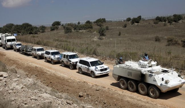 A convoy of United Nations Disengagement Observer Force (UNDOF) vehicles is seen as it leaves the Syrian side of the Golan Heights into the Israeli-occupied side of the strategic plateau, on September 15, 2014. Troops of the UNDOF were withdrawing from the Syrian part of the Golan Heights due to security reasons. The UNDOF is monitoring a 1974 ceasefire agreement between Israel and Syria on the Golan Heights. AFP PHOTO / JALAA MAREY